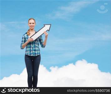 happiness, education and people concept - smiling young woman arrow poiting up over blue sky background