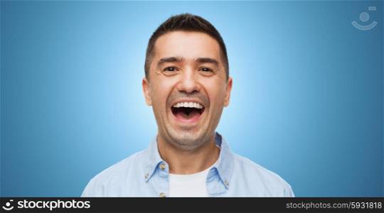 happiness, emotions and people concept - laughing man over blue background