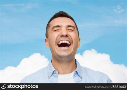 happiness, emotions and people concept - laughing man over blue sky and cloud background