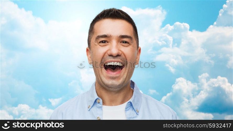 happiness, emotions and people concept - laughing man over blue sky and clouds background