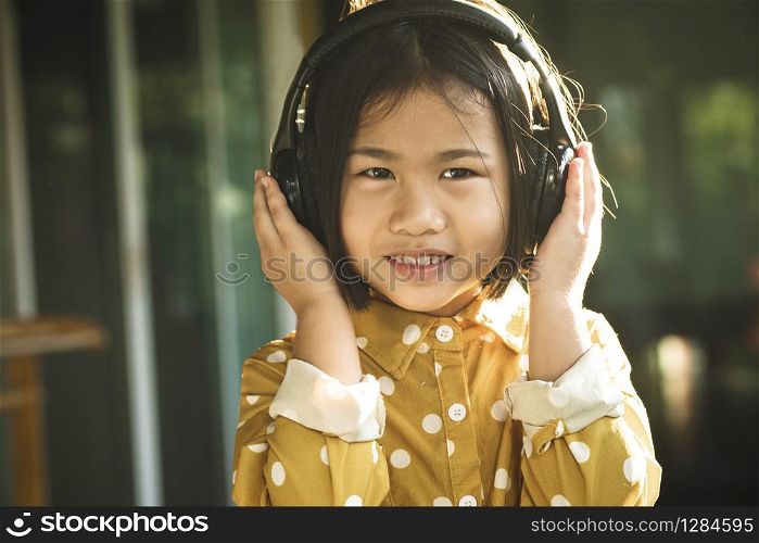 happiness face of asian children listening music in head phone