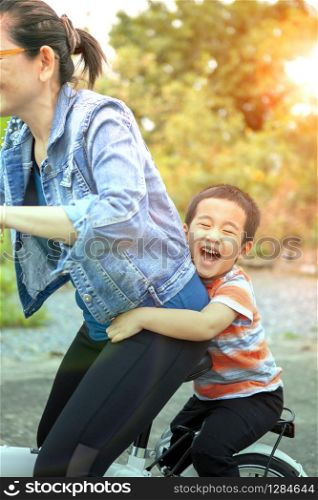 happiness face of asian children playing on bicycle with mother for families relationship