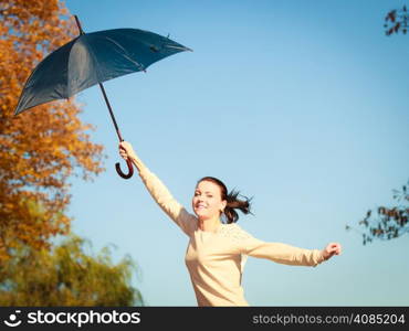 Happiness freedom and people concept. Casual young woman teen girl jumping with blue umbrella in autumnal park, having fun outdoor