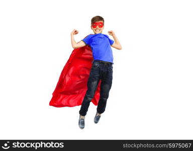 happiness, freedom, childhood, movement and people concept - boy in red super hero cape and mask flying in air