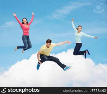 happiness, freedom, friendship, movement and people concept - group of smiling teenagers jumping in air over blue sky with white cloud background