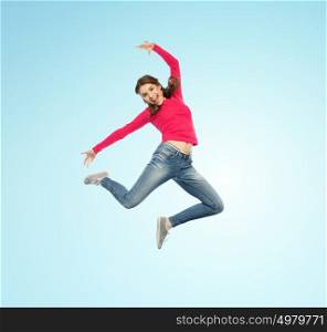 happiness, freedom, motion and people concept - happy young woman jumping or dancing in air over blue background. happy young woman jumping in air or dancing