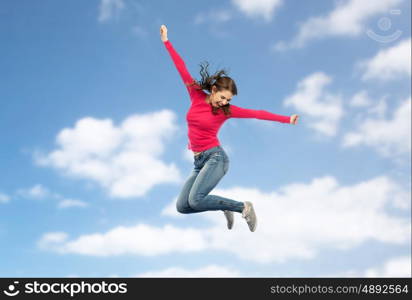 happiness, freedom, motion and people concept - smiling young woman jumping in air over blue sky and clouds background