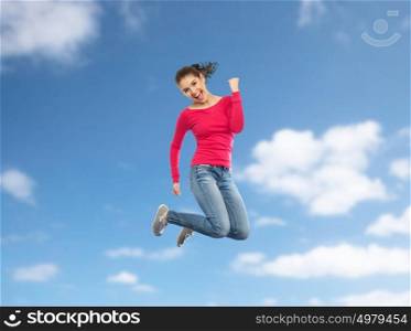 happiness, freedom, motion and people concept - smiling young woman jumping in air over blue sky background. smiling young woman jumping in air