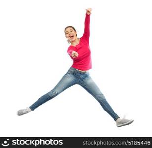 happiness, freedom, motion and people concept - smiling young woman jumping in air and pointing finger to you over white background. smiling young woman jumping in air