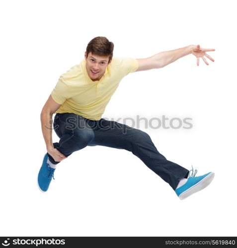 happiness, freedom, movement and people concept - smiling young man jumping in air