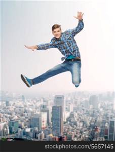 happiness, freedom, movement and people concept - smiling young man jumping in air over city background
