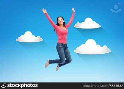 happiness, freedom, movement and people concept - smiling young woman jumping in air over blue sky with white clouds background