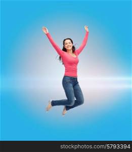 happiness, freedom, movement and people concept - smiling young woman jumping in air over blue laser background