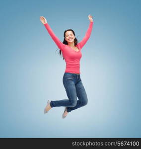 happiness, freedom, movement and people concept - smiling young woman jumping in air over blue background