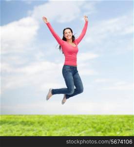 happiness, freedom, movement, summer and people concept - smiling young woman jumping in air over natural background