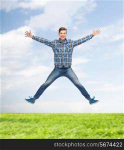 happiness, freedom, vacation, summer and people concept - smiling young man jumping in air over natural background