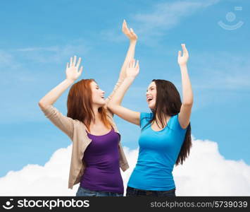 happiness, friendship and people concept - smiling teenage girls having fun over blue sky and cloud background