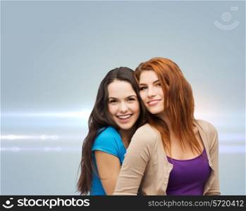 happiness, future, friendship and people concept - smiling teenage girls hugging over gray background with laser light