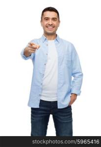happiness, gesture and people concept - smiling man pointing finger on you