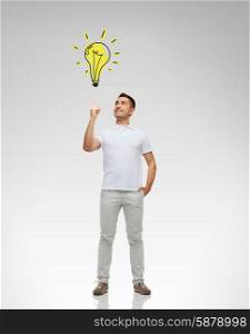 happiness, gesture and people concept - smiling man pointing finger up to lighting bulb doodle over gray background