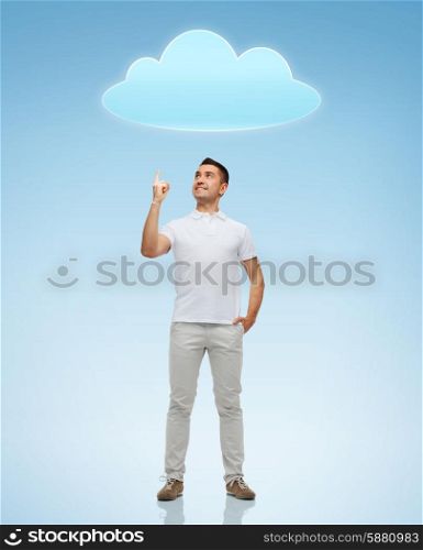 happiness, gesture and people concept - smiling man pointing finger up to cloud over blue background