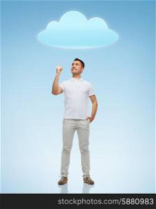 happiness, gesture and people concept - smiling man pointing finger up to cloud over blue background