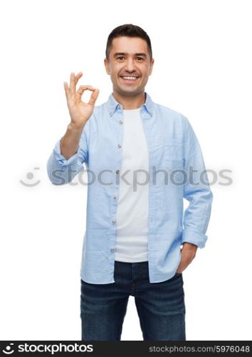 happiness, gesture and people concept - smiling man showing ok hand sign