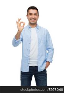 happiness, gesture and people concept - smiling man showing ok hand sign
