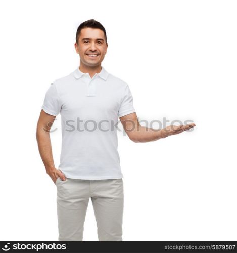 happiness, gesture and people concept - smiling man showing something imaginary on empty palm