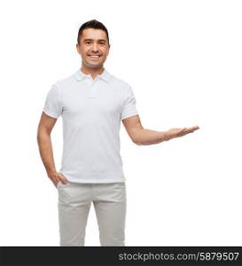 happiness, gesture and people concept - smiling man showing something imaginary on empty palm