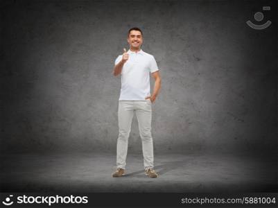 happiness, gesture and people concept - smiling man showing thumbs up over concrete background