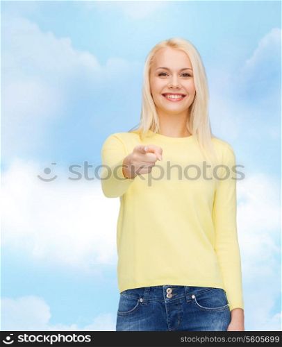 happiness, gesture and people concept - smiling woman pointing finger at you