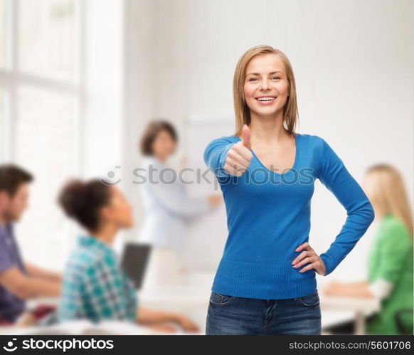 happiness, gesture and people concept - smiling young woman in casual clothes showing thumbs up