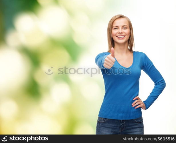 happiness, gesture and people concept - smiling young woman in casual clothes showing thumbs up