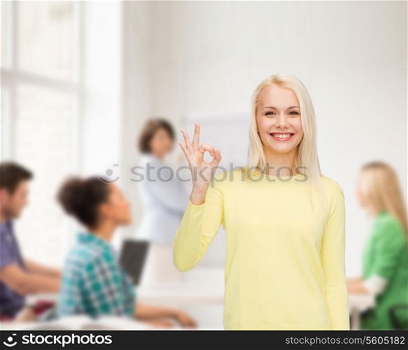 happiness, gesture and people concept - young businesswoman showing ok sign