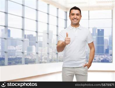 happiness, gesture, real estate and people concept - smiling man showing thumbs up over empty apartment or office room with big window and city view background