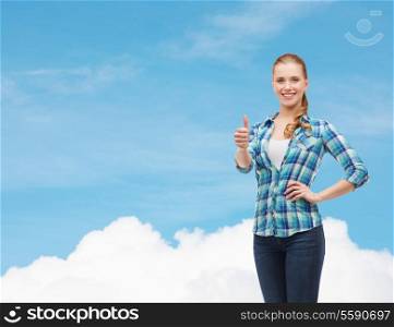 happiness, gesutre and people concept - smiling young woman in casual clothes showing thumbs up over blue sky background