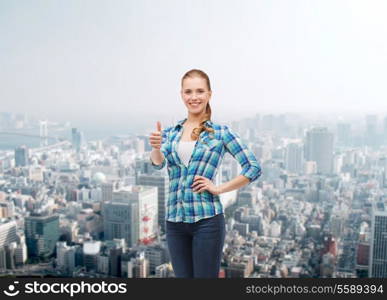 happiness, gesutre and people concept - smiling young woman in casual clothes showing thumbs up