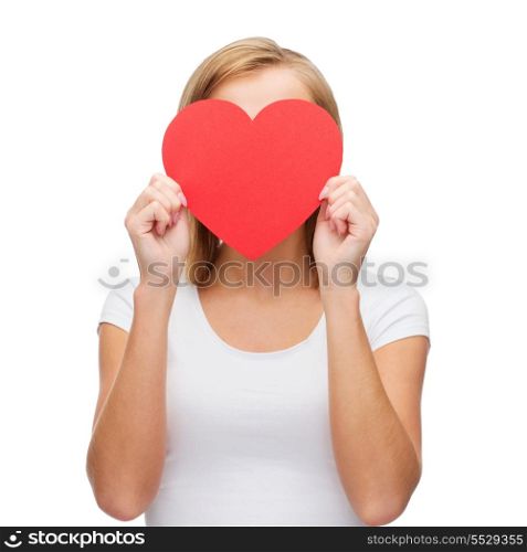 happiness, health and love concept - woman in white t-shirt covering her face with red heart