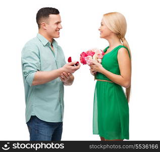 happiness, holidays, celebration and couple concept - smiling couple with flower bouquet and ring in a box