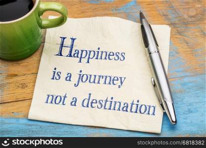 Happiness is a journey, not a destination - handwriting on a napkin with a cup of espresso coffee