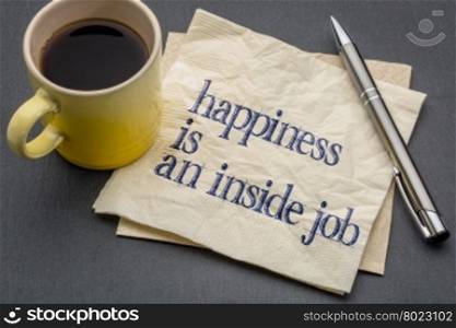 Happiness is an inside job - inspirational handwriting on a napkin with cup of coffee against gray slate stone background