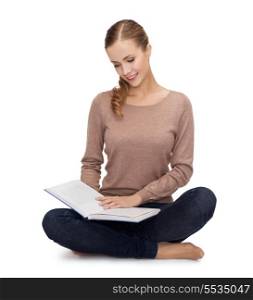 happiness, leisure and people concept - smiling young woman sitting on floor and reading book