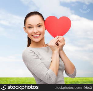 happiness, love and health concept - smiling asian woman with red heart