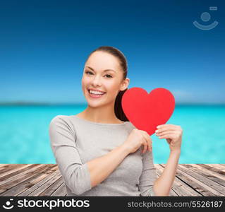 happiness, love and health concept - smiling asian woman with red heart