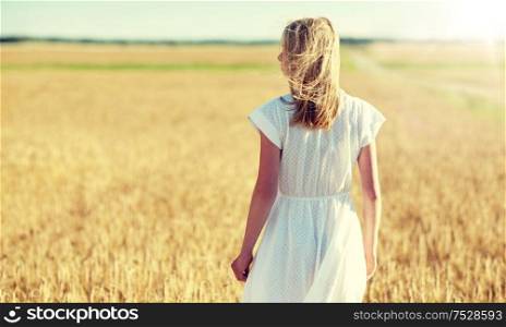 happiness, nature, summer holidays, vacation and people concept - young woman in white dress on cereal field. young woman in white dress on cereal field