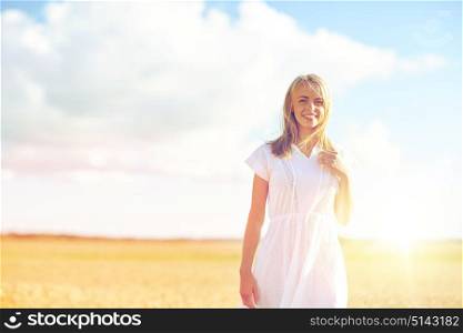 happiness, nature, summer, vacation and people concept - happy smiling young woman or teenage girl on cereal field. happy young woman or teenage girl on cereal field