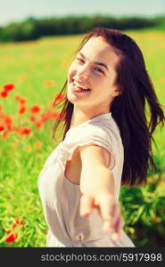 happiness, nature, summer, vacation and people concept - laughing young woman on poppy field