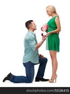 happiness, proposal, engagement and celebration concept - smiling couple with flower bouquet and ring in a box