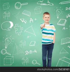 happiness, school, education, gesture and people concept - smiling boy pointing his finger at you over green board with doodles background